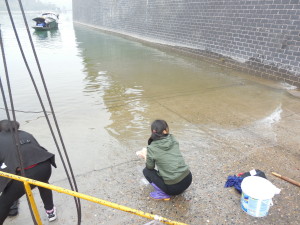 This woman from the boat is washing clothes in the river.