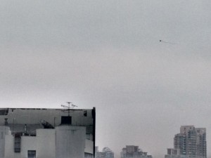 Kite being flown from a roof in Shanghai.